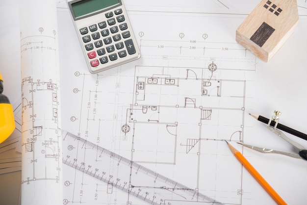 Top view of house plan blueprint paper with repair tools on\
table desk at architecture office