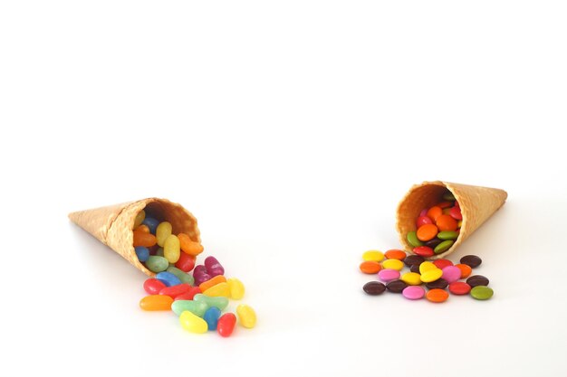 Top view of ice cream cone with colorful candy on the white background