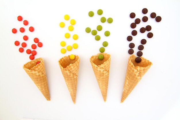 Top view of ice cream cone with colorful candy on the white background