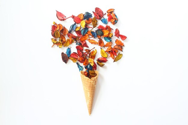 Top view of ice cream cone with colorful flower on the white background