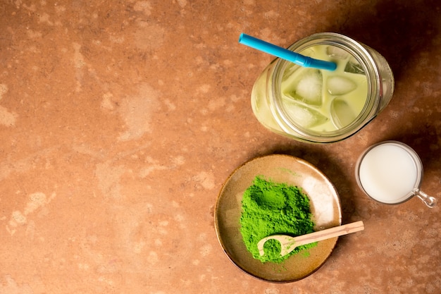 Photo top view of iced green tea iced green tea with milk on brown grunge background.