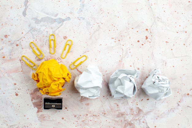 写真 しわくちゃの黄色い紙の宝石クリップ鉛筆削りしわくちゃの紙とテーブル上の上面図のアイデア電球の概念