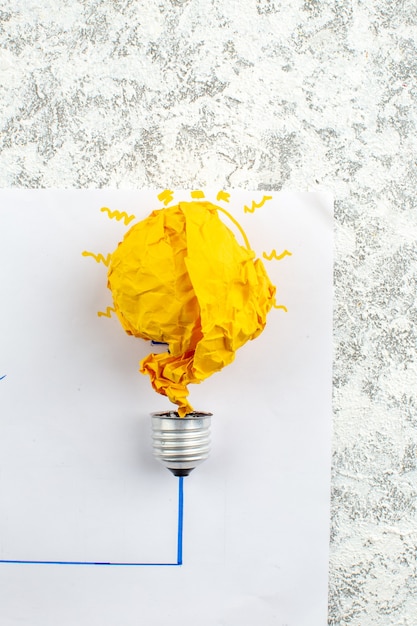 Photo top view idea light bulb concept with yellow crumpled paper on paper on table