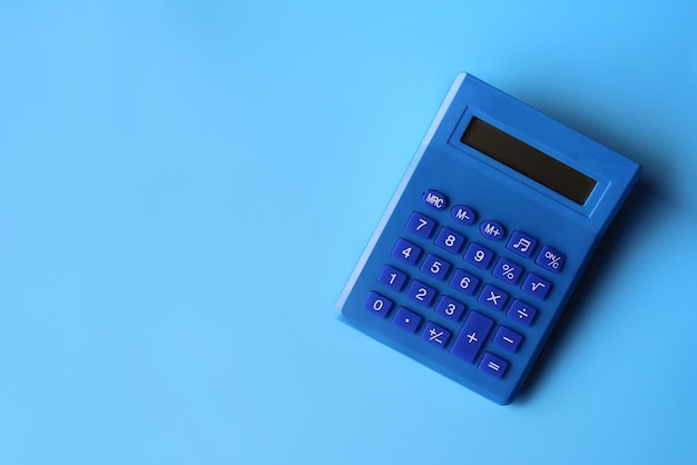 Top view image of blue calculator on blue background with copy space