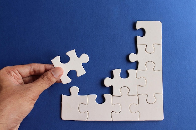 Top view image of incomplete jigsaw puzzle on blue background