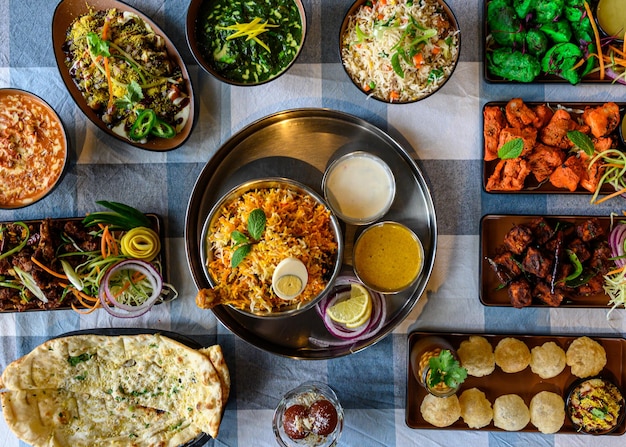 Top view of the Indian food Biryani with side dishes on a tablecloth