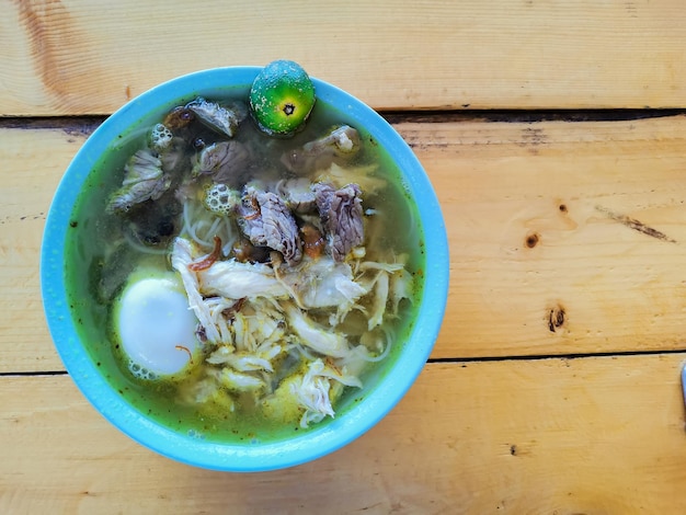Photo top view indonesian traditional food known as soto campur on the table.