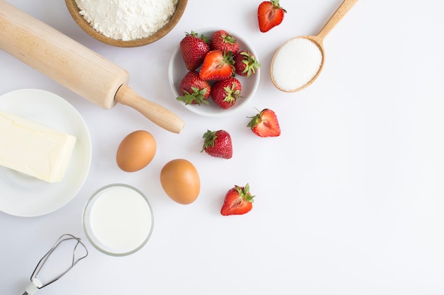 Top view of ingredients for making strawberry pie or cake on the white background Copy space
