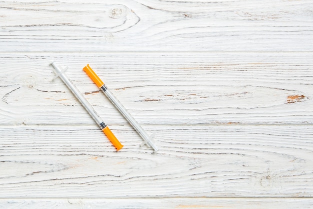 Top view of insulin syringe prepared for injection at wooden