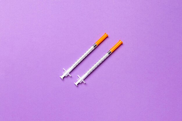 Top view of insulin syringes ready for injection on colorful background Diabetic concept with copy space