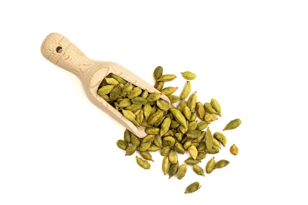 Top view on isolated heap of cardamom seeds in a wooden scoop