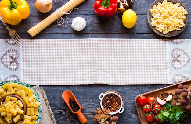 Top view of italian ingredients for spaghetti, over a wood surface.