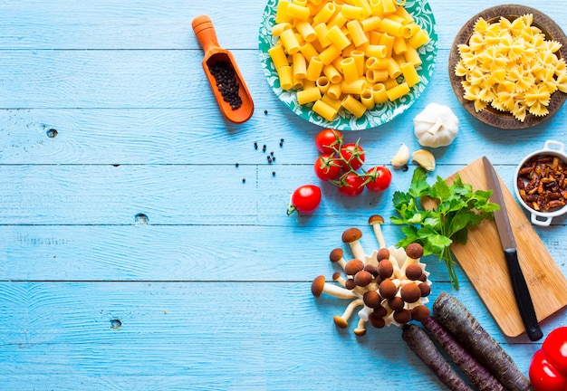 Top view of italian ingredients for spaghetti, over a wood surface.