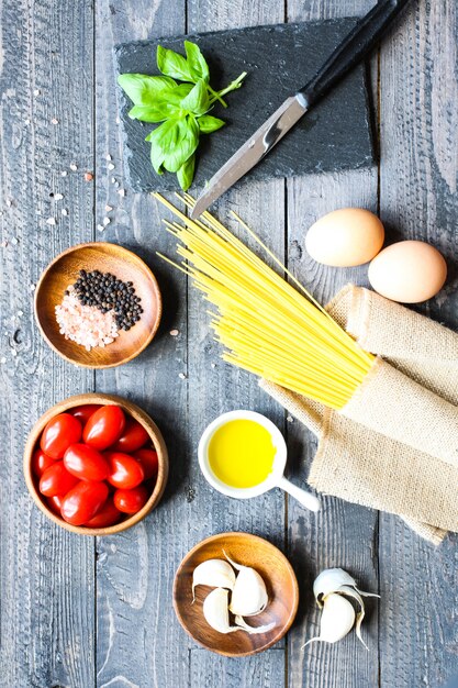 Top view of italian ingredients for tomato and basilic spaghetti.