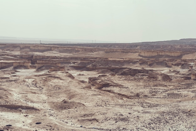 Верхний вид на Иудейскую пустыню и Мертвое море Пустыня Израиля Неровная скалистая и песчаная поверхность израильской пустыни Сухой климат и засушливая почва Человек живет на бездождливой территории