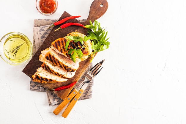 그릇 건강 식품 복사 공간에 야채 토마토 소스와 절단 나무 보드에 구운 치킨 필렛의 육즙 조각의 상위 뷰