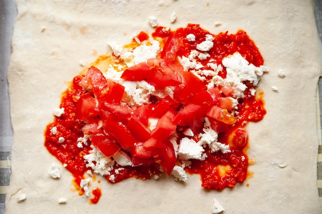 부리토를 위한 치즈와 칠리 페퍼 소스로 채워진 육즙이 많은 토마토의 상위 뷰