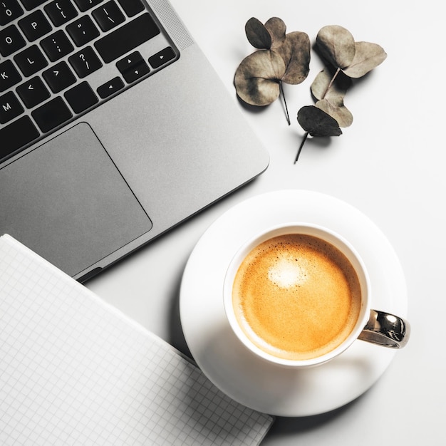 Top view of laptop and coffee on grey background