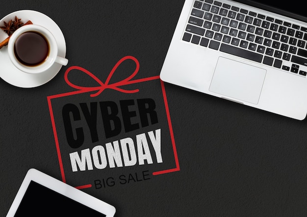 Top view of laptop and cup of tea with cyber monday lettering on black background. Copyspace for your advertising. Black friday, sales, finance, advertising, money, finance, purchases concept.