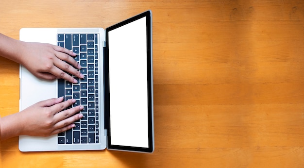 Top view of laptop in hands on a wooden floor  