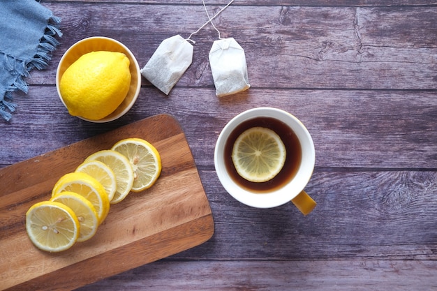 Top view of lemon tea and slice of lemon on wooden background