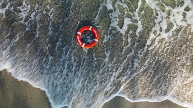 Вид сверху на спасательный круг на берегу моря Спасательное кольцо, плавающее в море