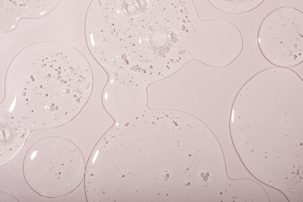 Photo top view of liquid cosmetics gel with bubbly structure on pastel background.good as cosmetic mockup.
