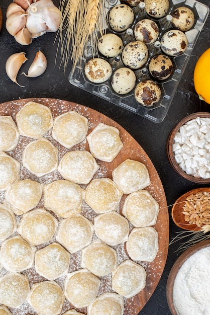 Top view little dough pieces with flour on a dark background pie dumpling dough bun hotcake color cake meat