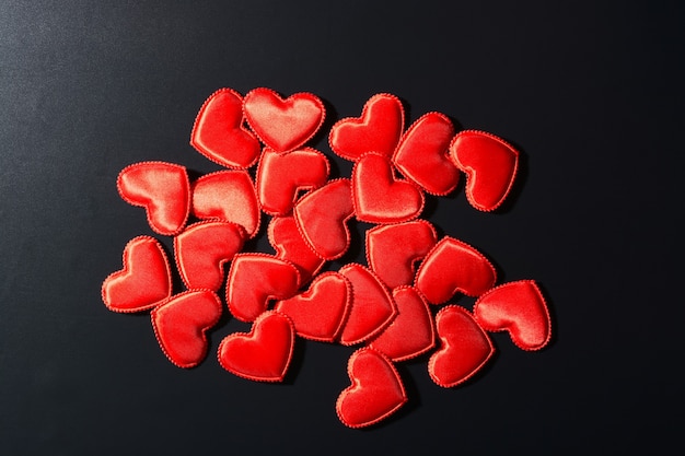 Top view of little red hearts on a black background