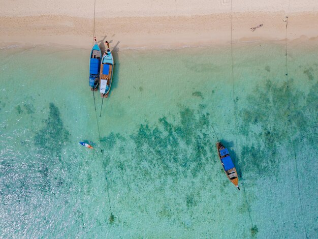 Photo top view at longtail boats in a blue ocean at the beach of koh ngai island thailand