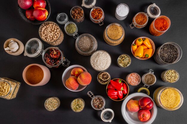 Photo top view of a lot of glass jars filled with all kinds of spices and fruits