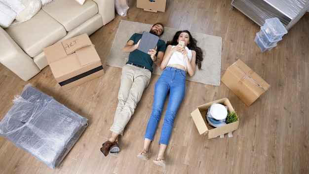 Top view of a loving couple lying on the floor using tablet.Happy couple