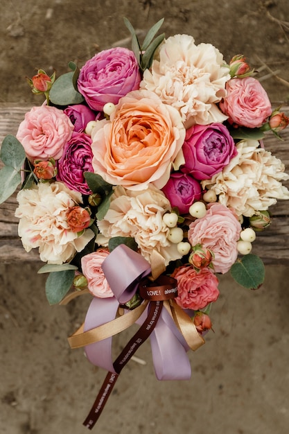 Foto vista dall'alto del bouquet di lusso di rose rosse e arancio vista dall'alto con fiocco rosa sulla festa di san valentino