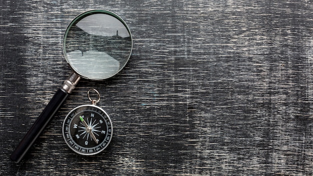 Photo top view magnifying glass and compass