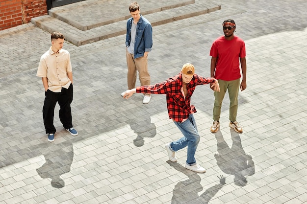 Top view at male breakdancing team performing outdoors in city lit by sunlight copy space