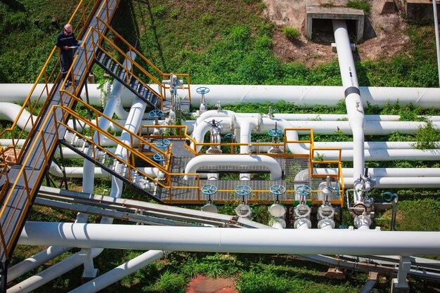 Ispezione del lavoratore di sesso maschile vista dall'alto alla valvola del controllo visivo dell'industria petrolifera e del gas della conduttura