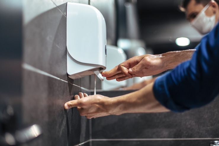 Photo top view. a man carefully washes his hands in the bathroom
