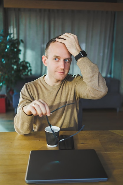 Top view of man in casual clothes with coffee sitting at workplace using netbook while working during working day A successful businessman works on a laptop computer