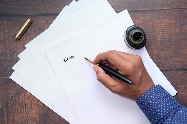 Top view of man hand writing a letter with fountain pen