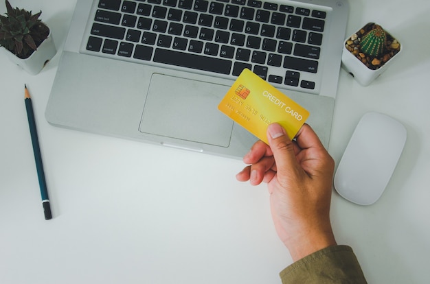 Top view man holding a credit card on the desk.Online shopping business, pay by credit card