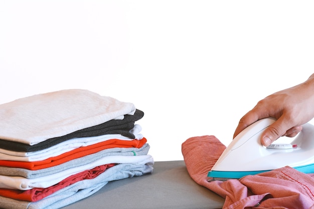 Top view of man ironing pink  shirt on ironing board 