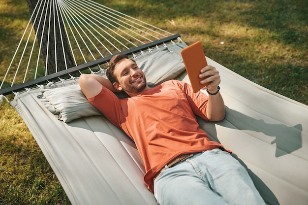 Top view of man lying with tablet