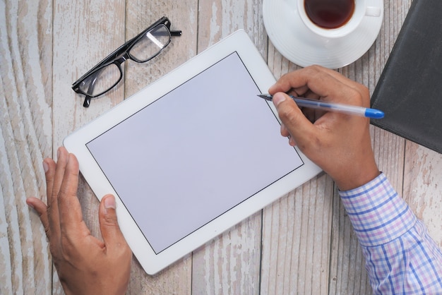 top view of man's hand working on digital tablet at office desk