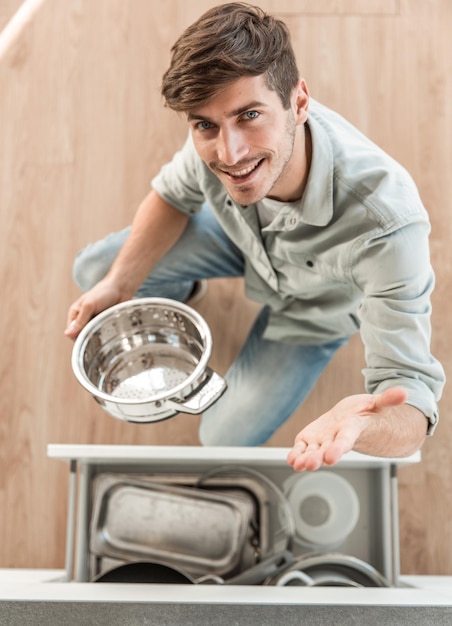 Foto vista dall'alto di un uomo che tira fuori gli utensili dal tavolo della cucina