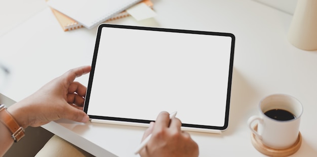 Top view of man using blank screen tablet in minimal office