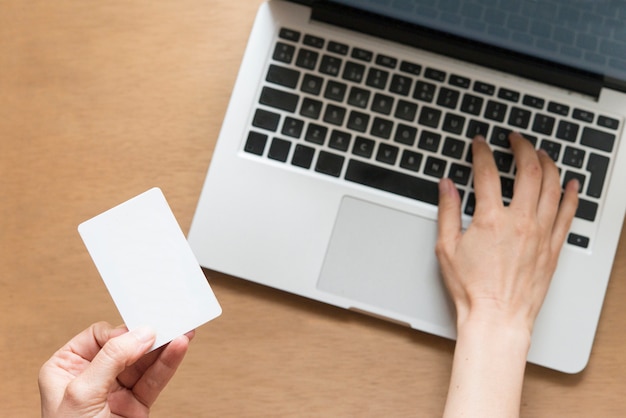 Top view of man using credit card and laptop