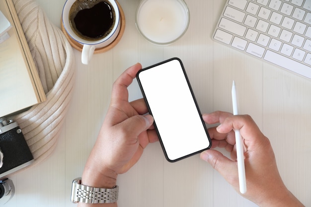 Top view man using mobile smart phone on workplace	