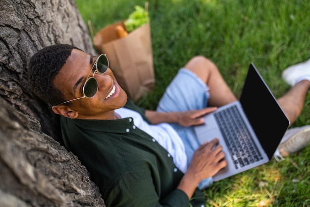 Photo top view of man with laptop smiling at camera