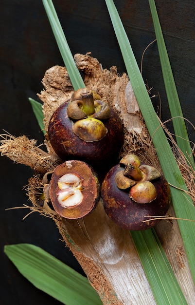 Top view of Mangosteen tropical fruit on colored dark table