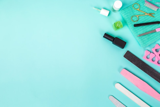 Top view of manicure and pedicure equipment on blue background. Still life. Copy space